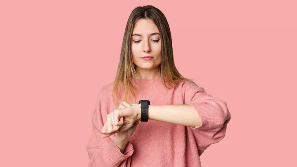 Frau schaut auf eine Armbanduhr - Zeitanzeige
