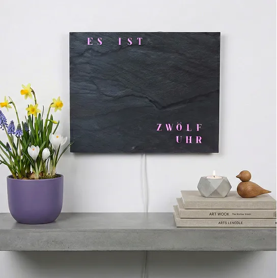 WordClock mit Blumen auf Sideboard