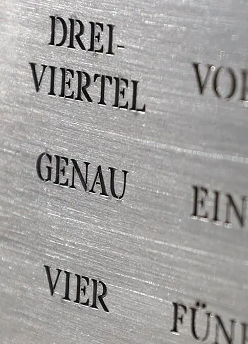 Metal surface with engraved word clock characters